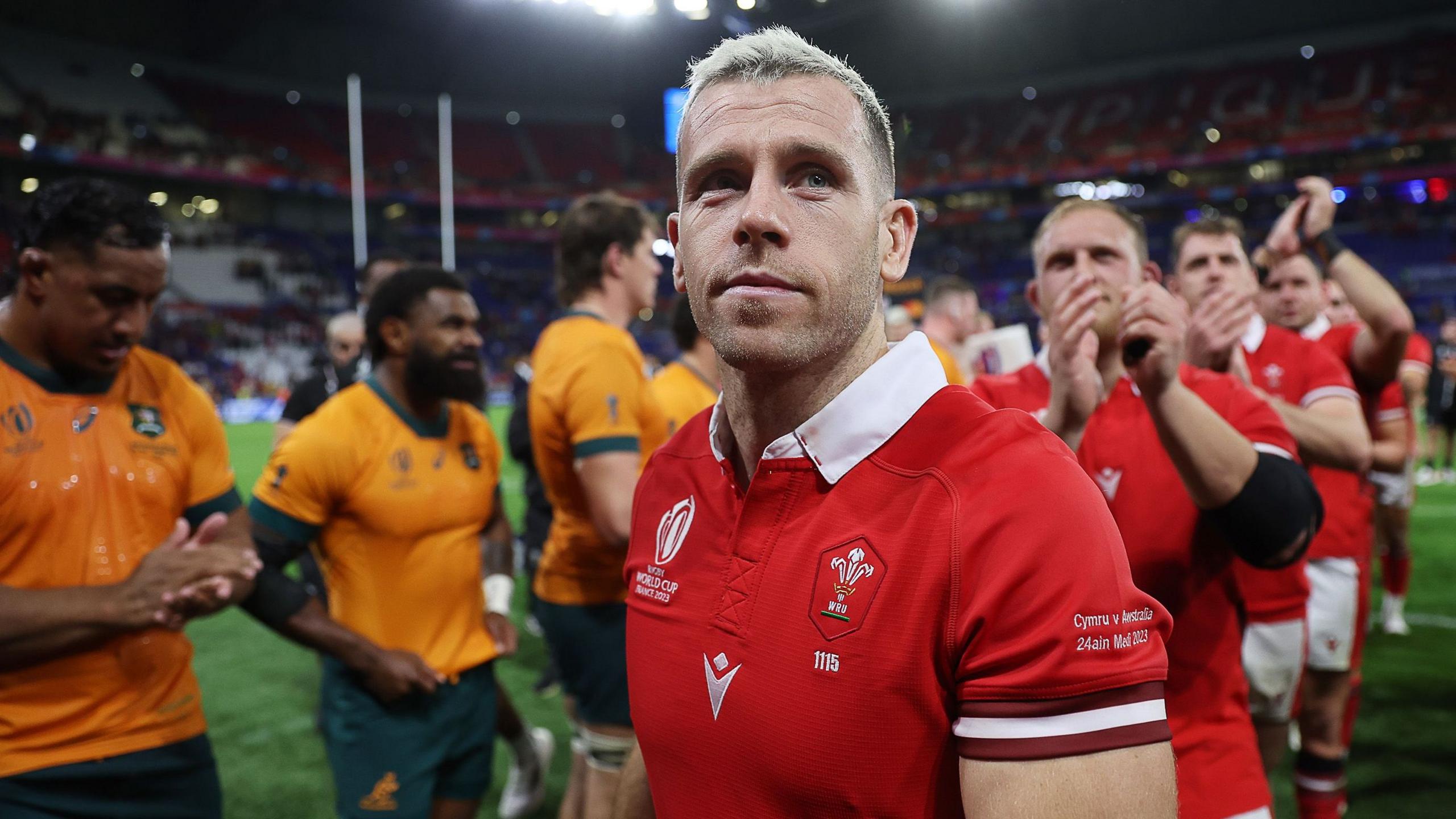Gareth Davies in a red Wales jersey walking off pitch past Australia players