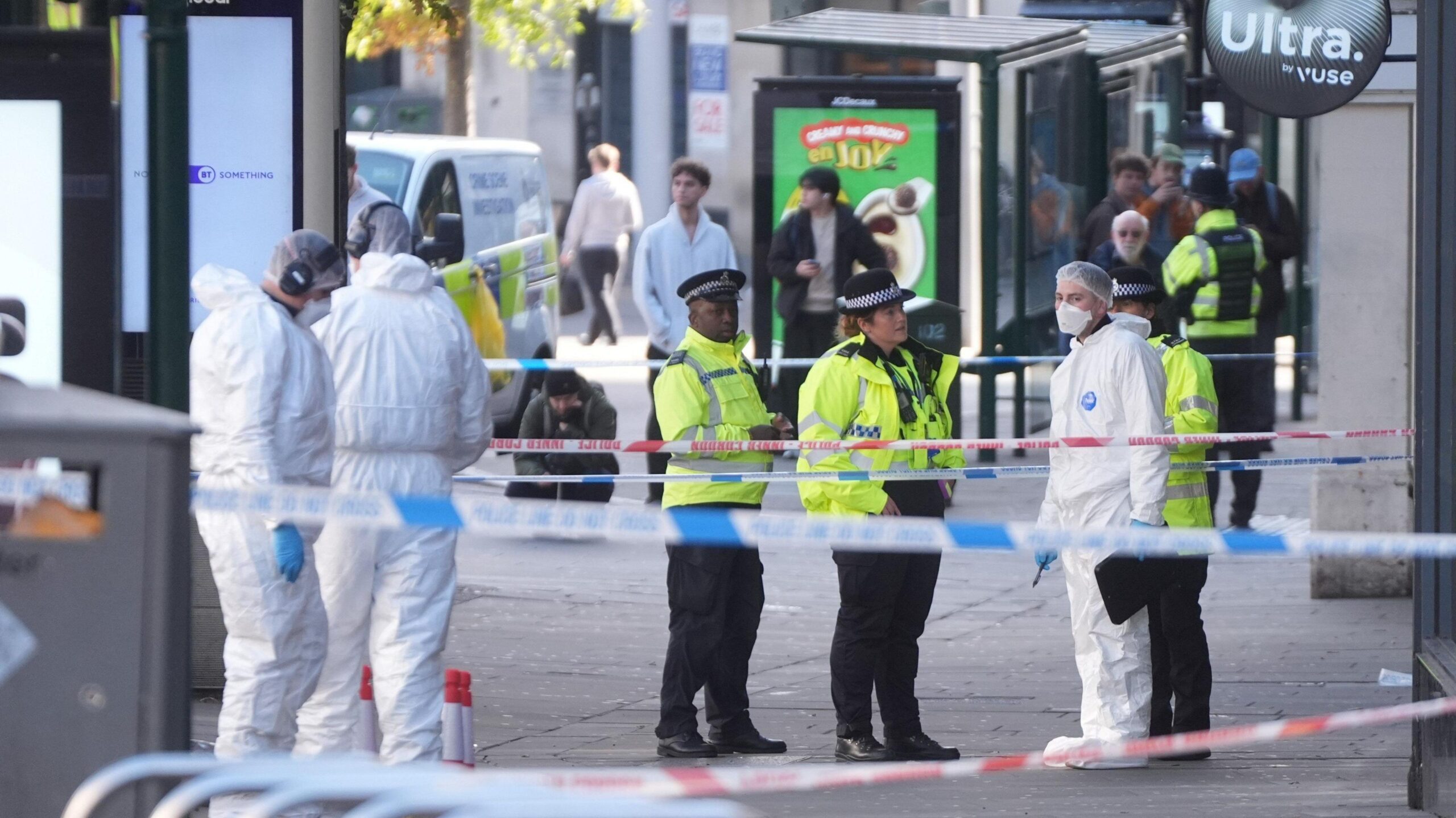 A group of uniformed police officers standing next to forensic officers