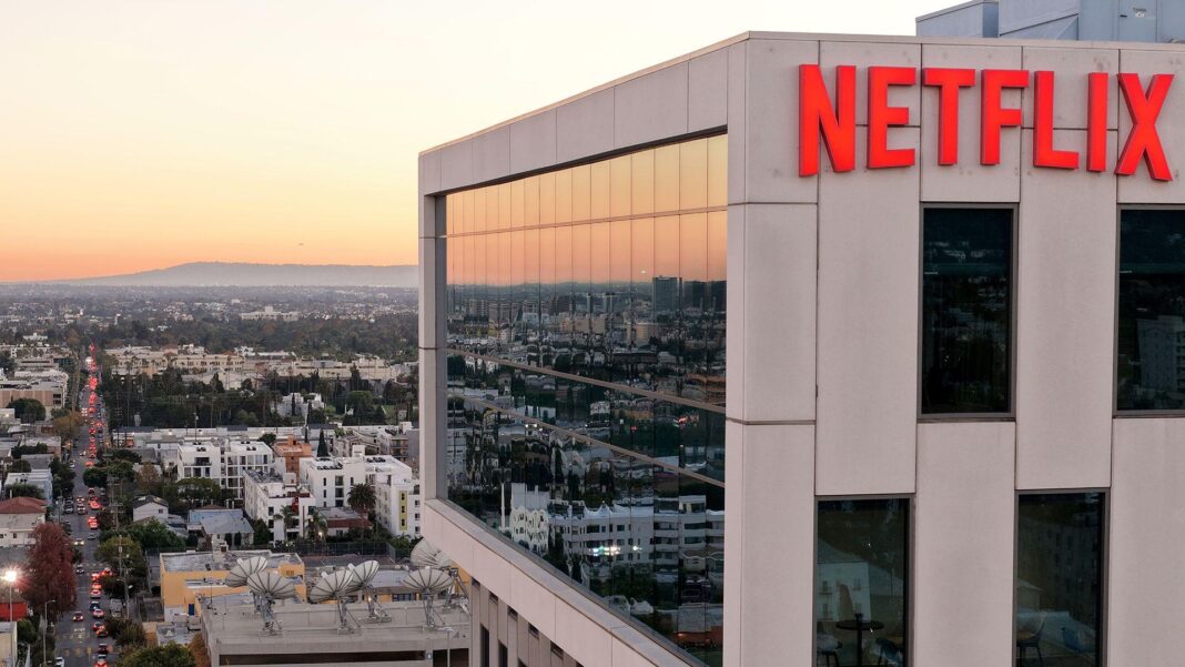 Netflix to lay off 1,000 staff in steepest cuts since 2022 A wide view shows the Netflix logo on the side of a cream coloured building at Netflix studios in 2025 in LA, with the iconic LA skyline in the background at sunset.