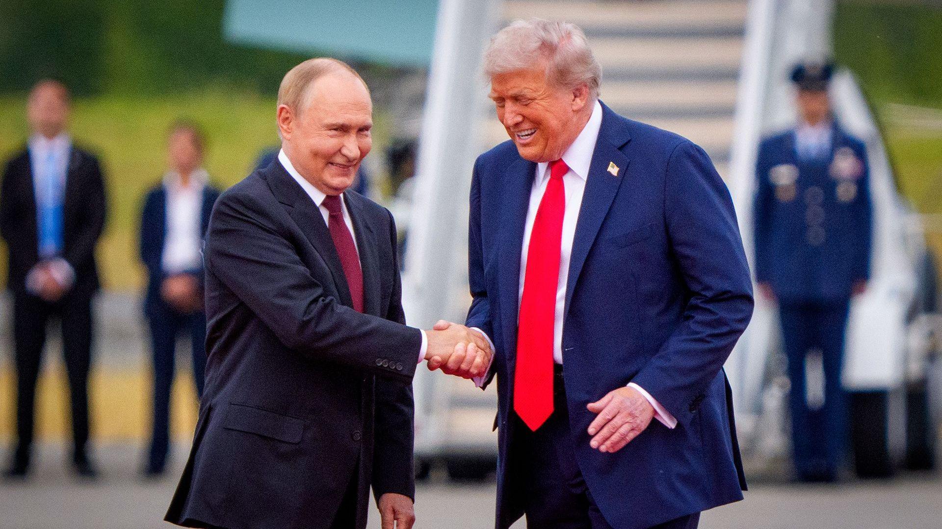 Donald Trump and Vladimir Putin shake hands and smile after Putin lands in the US