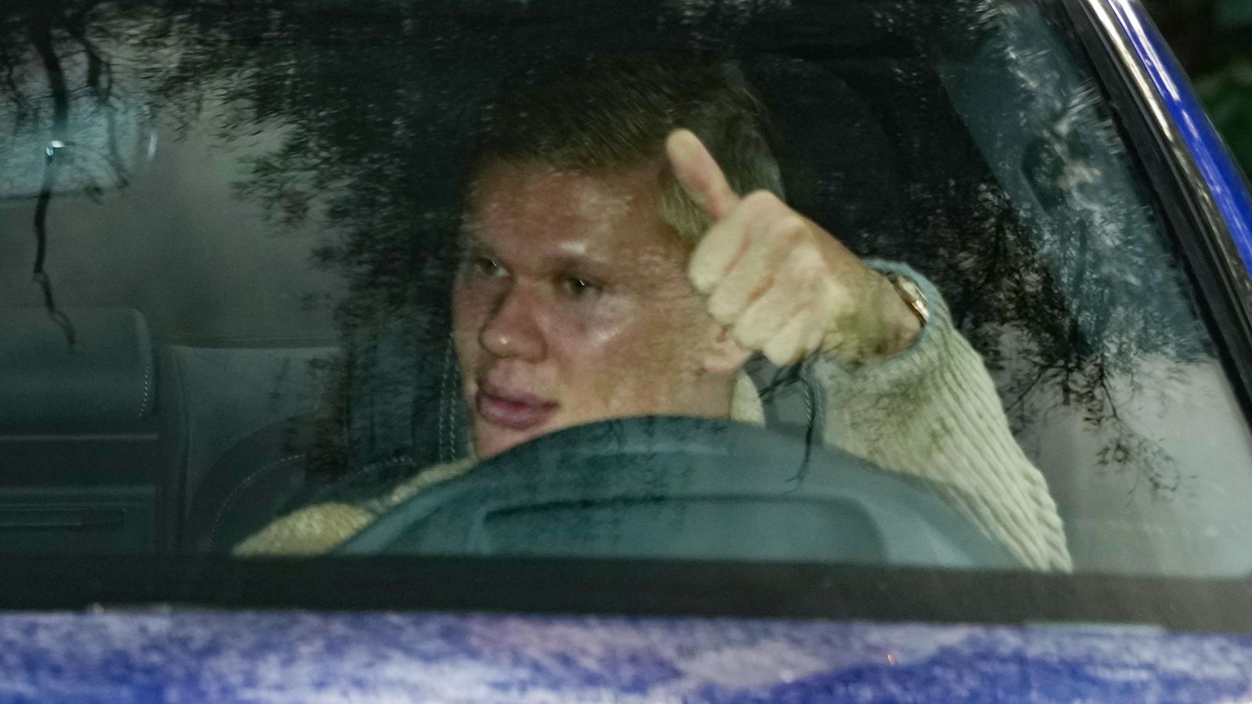 Erling Haaland gives a thumbs up to photographers as he arrives at training