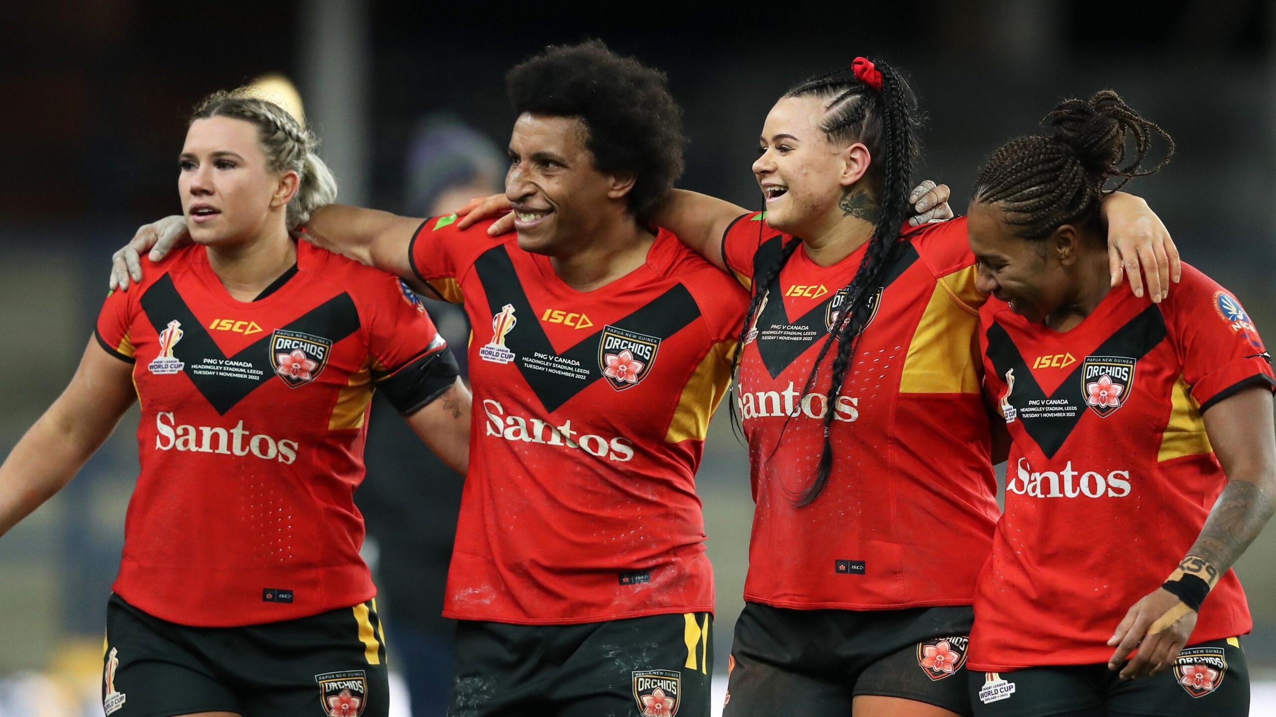 Four Papua New Guinea players link in a row, arms around each other's shoulders