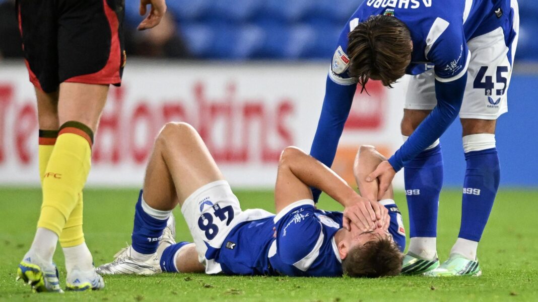 Injured Lawlor to miss Wales’ final Nations League games A team-mate consoles Dylan Lawlor who lies on the pitch in his blue and white Cardiff City kit covering his face with his hands.