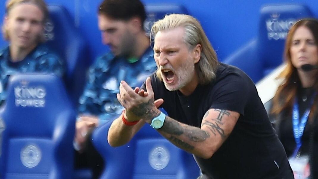 Robbie Savage, wearing a dark T-shirt, claps and shouts at his Peterborough players from the touchline