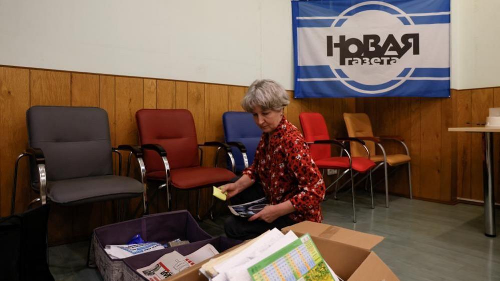A female employee packs up at the office of Russian newspaper Novaya Gazeta