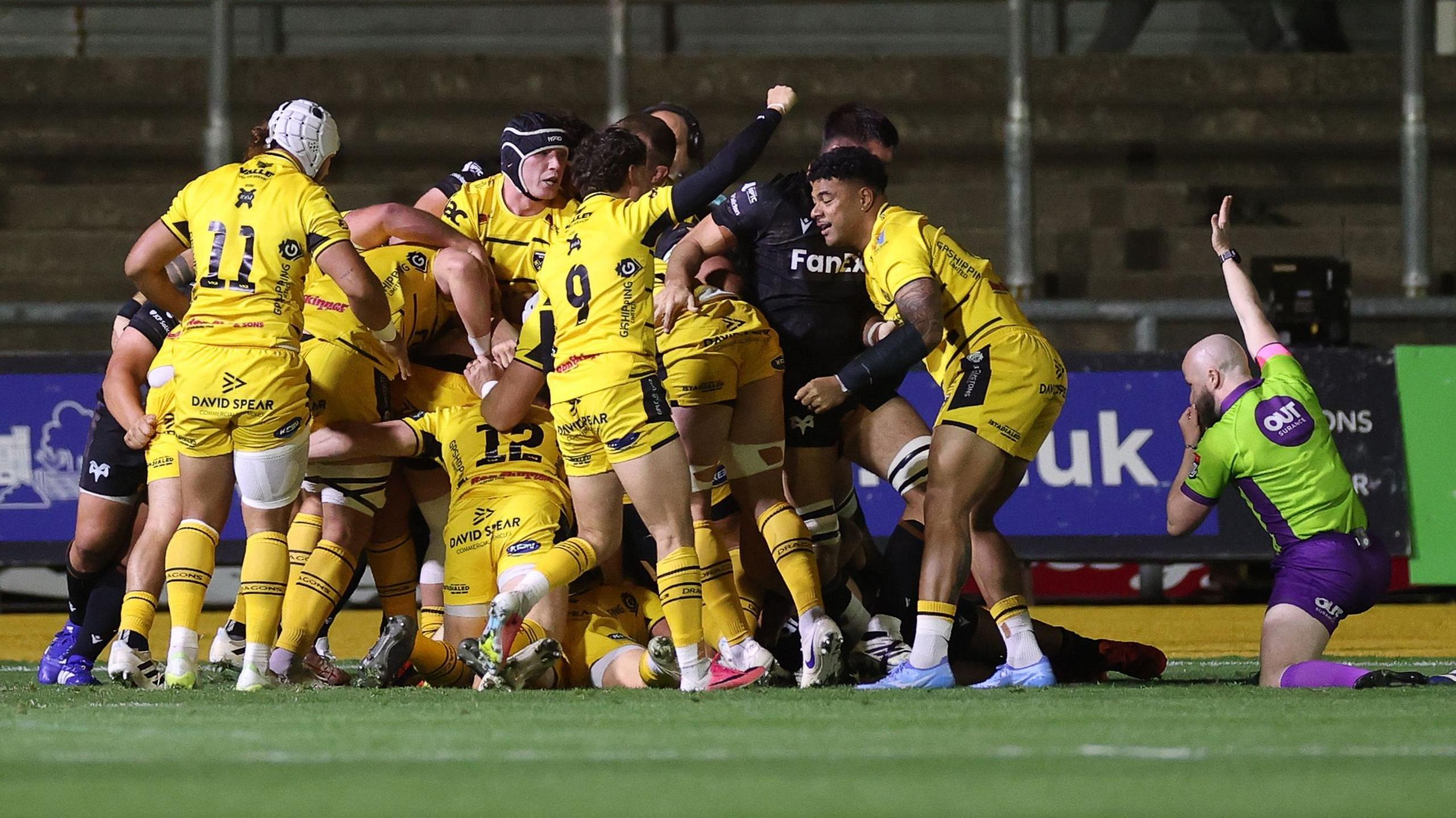Referee Robbie Jenkinson awards a try for Dragons against Ospreys