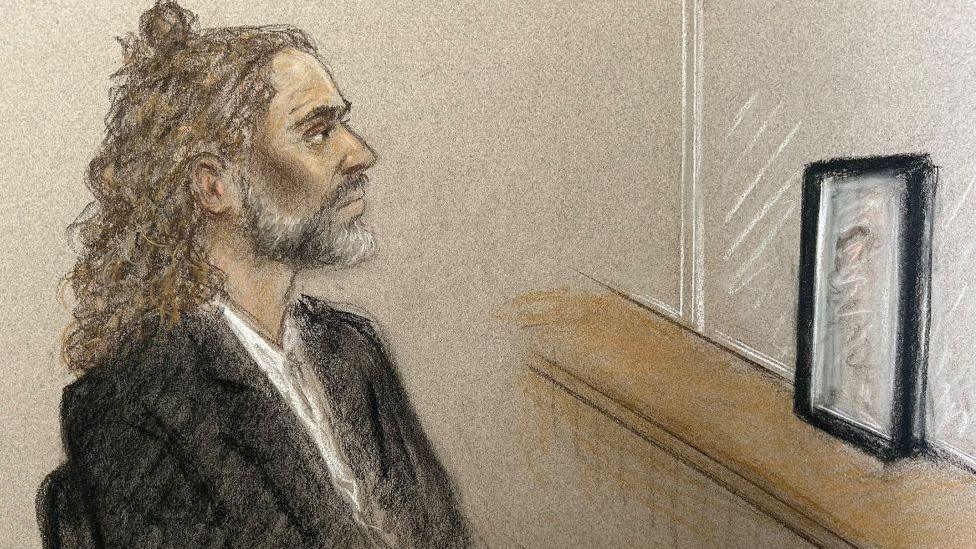 Court artist sketch of Russell Brand in the dock on 15 October, during trial at Southwark Crown Court, where he faces three charges of rape, indecent assault, and three counts of sexual assault, relating to six women