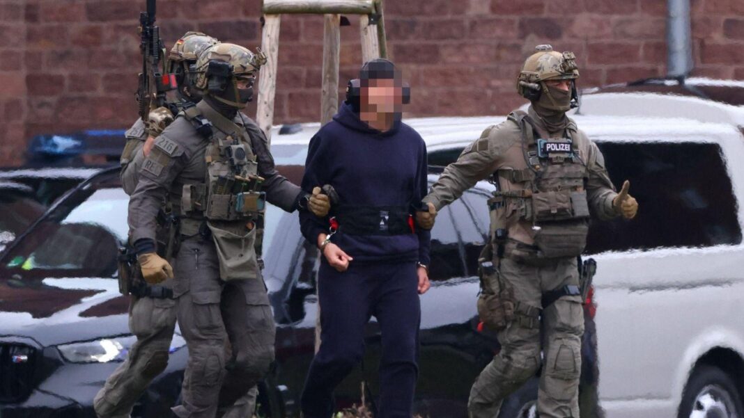 Serhii K flanked by armed police.
