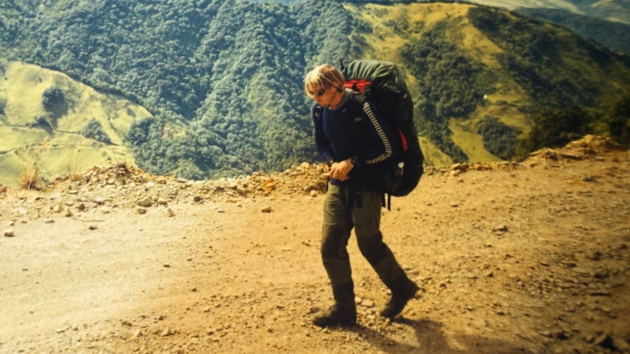 Karl Bushby, then in his late 20s, walking along a steep mountain dirt track.
