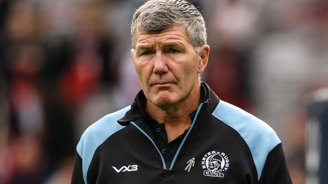 Baxter focuses on ‘reality’ of Exeter’s early form Rob Baxter looks straight ahead while standing on the pitch of a Prem match. He is wearing a black and blue Exeter Chiefs branded top