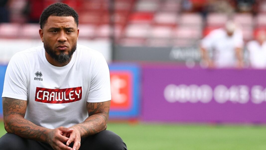 Colin Kazim-Richards looking pensive, wearing a white top with Crawley written on it