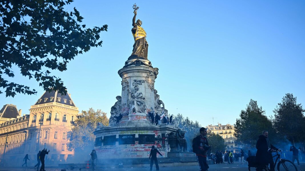 France’s government under pressure after weekend of widespread violence Protesters walk next to tear gas and the 'Statue de la Republique' as they gather as clashes erupted at Place de la Republique following a demonstration central Paris, on October 18, 2026.