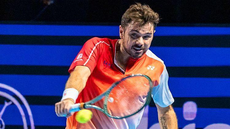 Stan Wawrinka, in white and orange tennis shirt, hits a one-handed backhand at the Swiss Indoors event in Basel