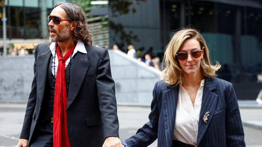 Russell Brand and Laura Brand holding hands and walking into court on Thursday