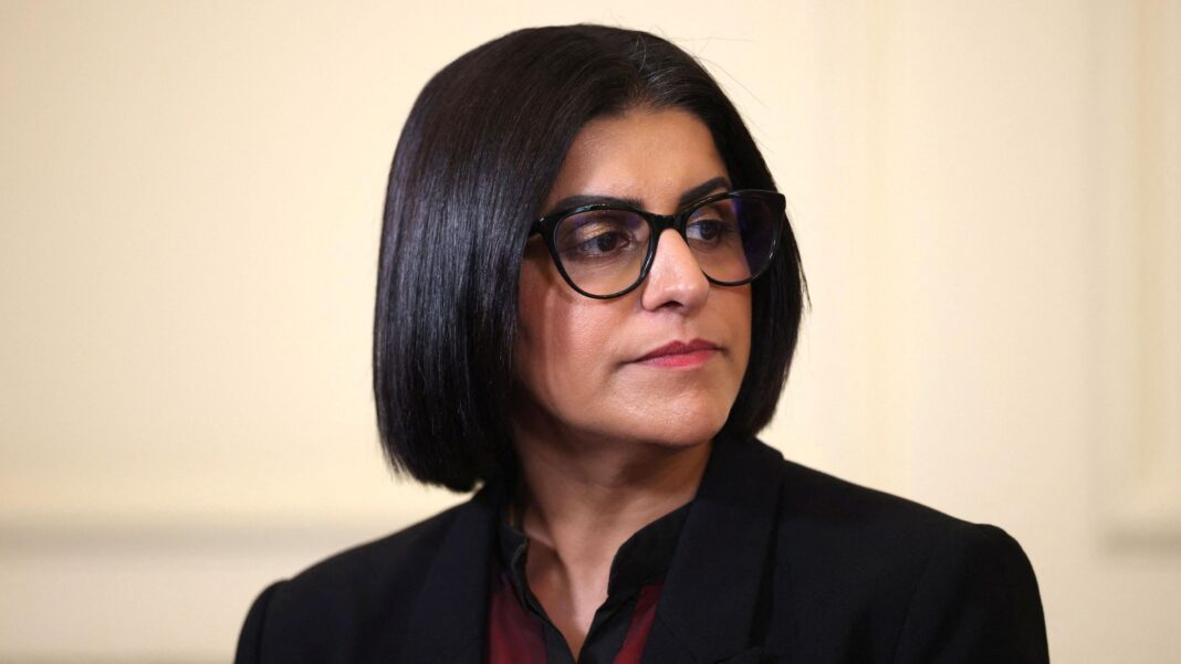 Government expands police support to political figures who are not MPs Headshot of Shabana Mahmood looking off-camera wearing black glasses, a black jacket and red shirt.