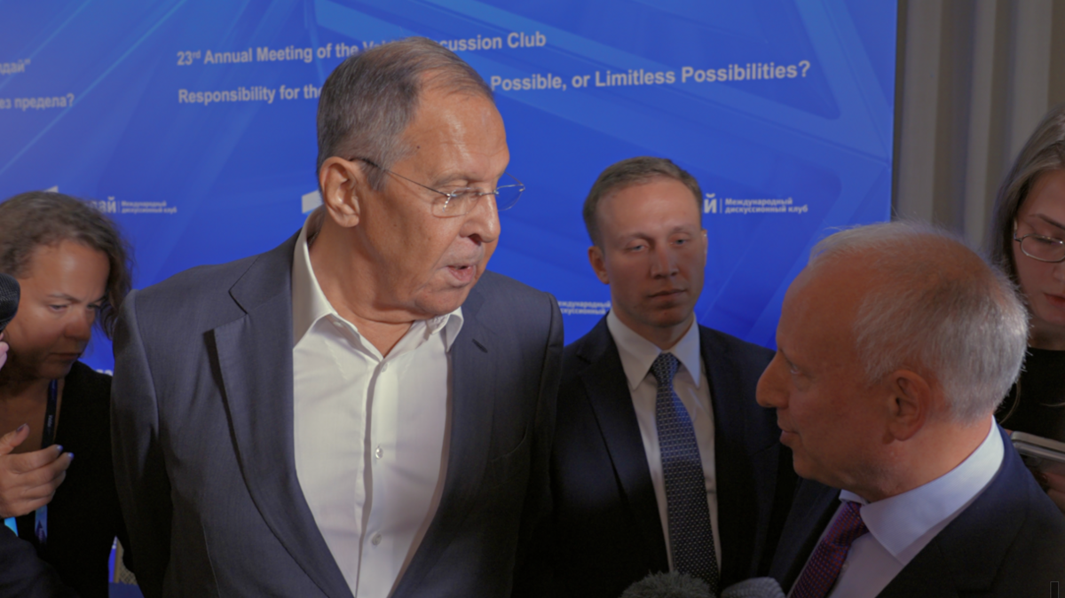Sergei Lavrov (left) in a grey suit and a white shirt with no tie speaks to Steve Rosenberg (right) at the Valdai Discussion Club