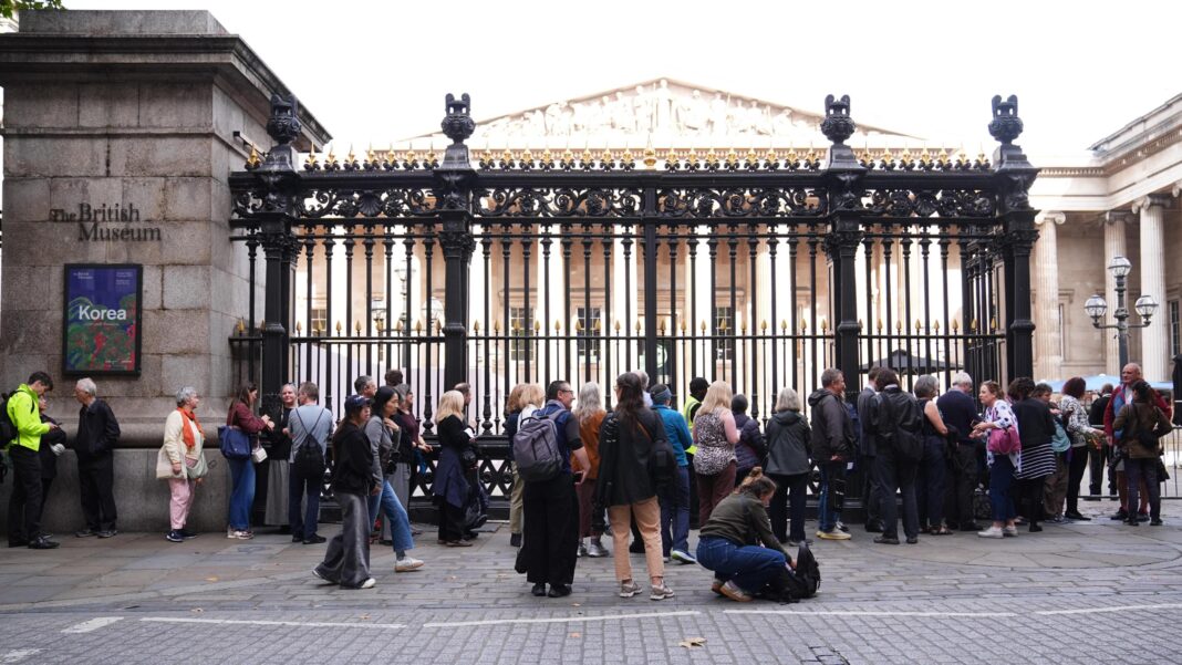People wait in line outside the British Museum in central London as the Bayeux Tapestry exhibition opens to members of the public