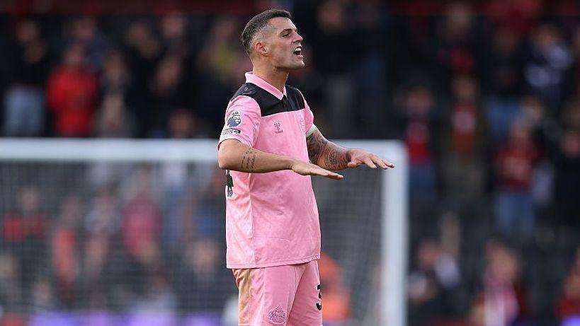 Sunderland midfielder Granit Xhaka, in pink kit, makes a palms-down gesture with both hands at full-time following the Bournemouth game