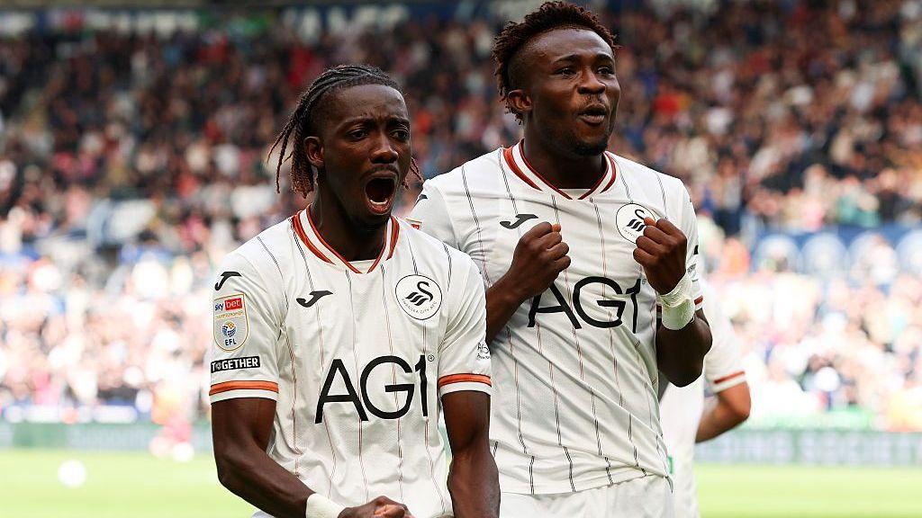 Moussa Yeo and Joseph Opoku celebrate a Swansea City goal, wearing white Swansea shirts