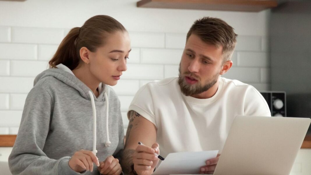 Heating oil customers face tough winter despite shake-up promise Couple look at a bill in their kitchen with a laptop in front of them.