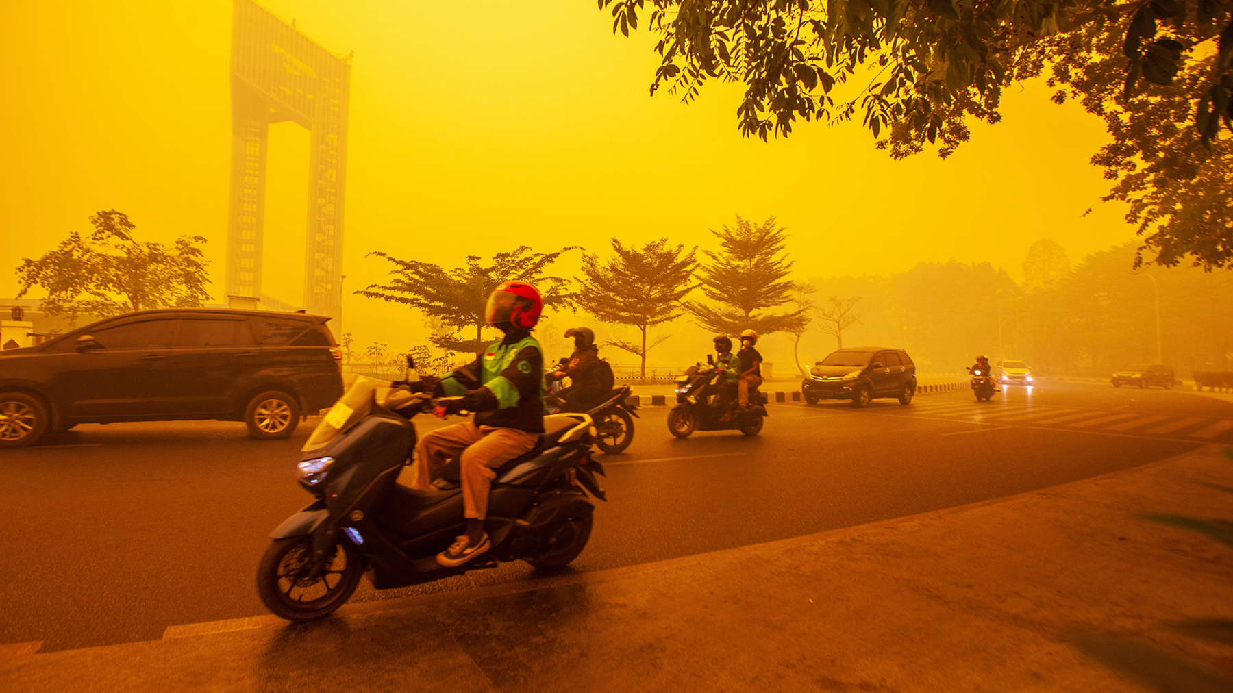 Motorists ride through thick haze from wildfires in Palangkaraya, Central Kalimantan, Indonesia, 14 October 2026. The sky is orange and yellow
