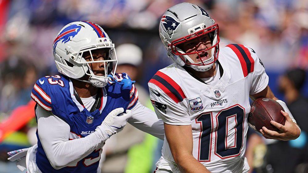 Drake Maye of the New England Patriots scrambles with the ball against Dee Alford of the Buffalo Bills