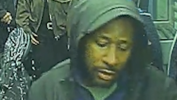 A CCTV image of Anthony Williams on a train. He is wearing a dark jacket and has his hood up.