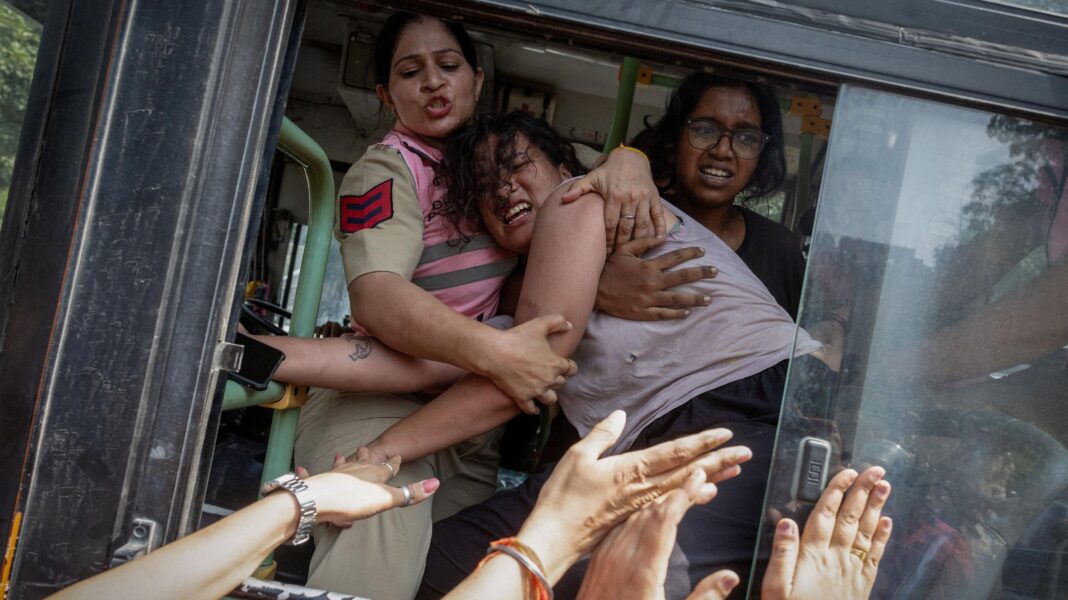 Policewomen try to stop a detained protestor to escape from a bus during a protest by the Cockroach Janta Party (CJP) seeking the resignation of India's Chief Election Commissioner Gyanesh Kumar, near the protest site in New Delhi, India, October 10, 2026. REUTERS/Adnan Abidi TPX IMAGES OF THE DAY