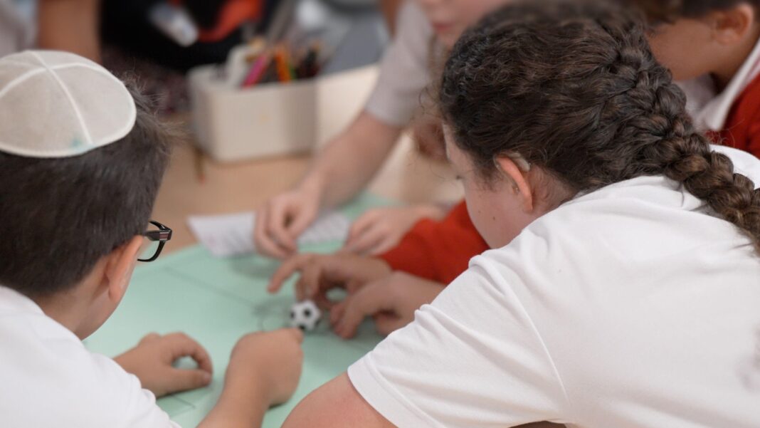 Jewish students work together at a table at school