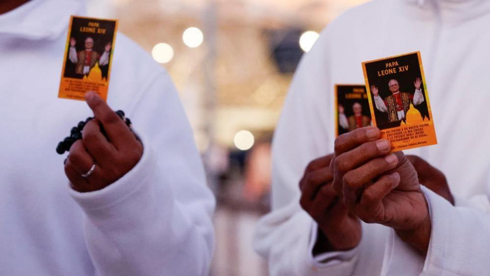 Nuns hold up an image of Pope Leo XIV outside Agostino Gemelli Hospital in Rome, Italy, 13 October 2026.