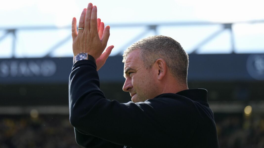 Steven Schumacher applauds wearing a wedding ring, a black wristwatch and a black jacket