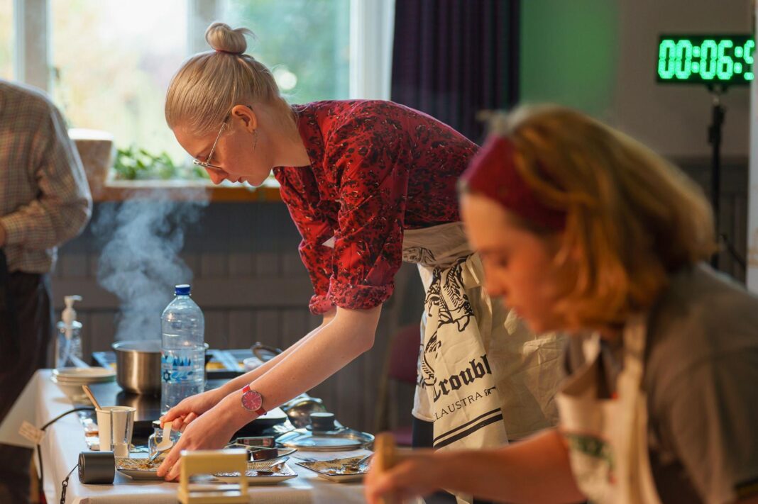 Porridge makers from opposite sides of globe triumph in world championship A woman prepares porridge over a steaming hotplate, with another woman out of focus in the foreground
