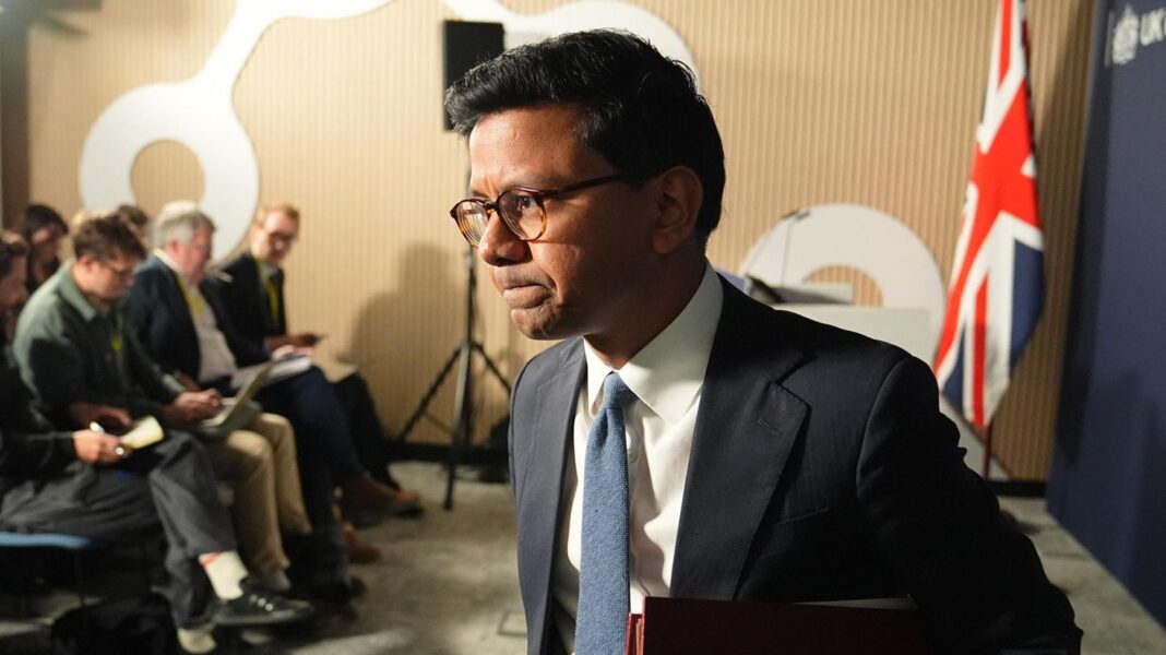 AI minister warns ‘likely’ UK’s cyber defences will be breached Kanishka Narayan walking away from podium after speaking in a suit with a blue tie against a union jack flag backdrop and blue background and memebers of te press behind him