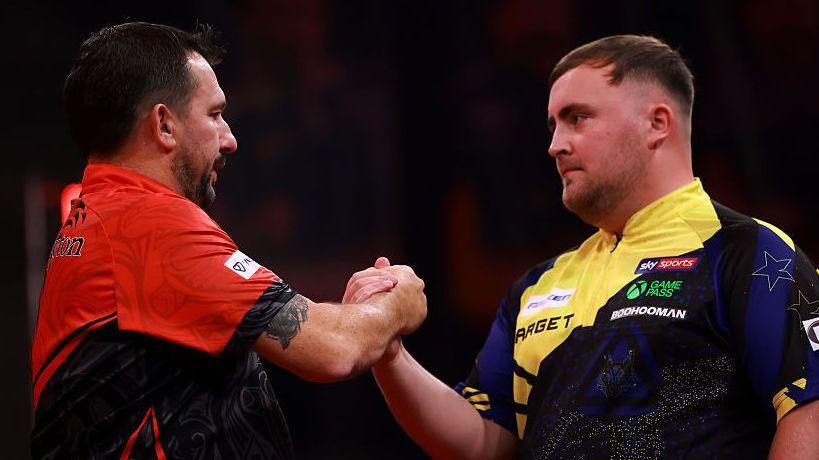 Jonny Clayton and Luke Littler shake hands after the former wins a World Darts Series of Darts quarter-final