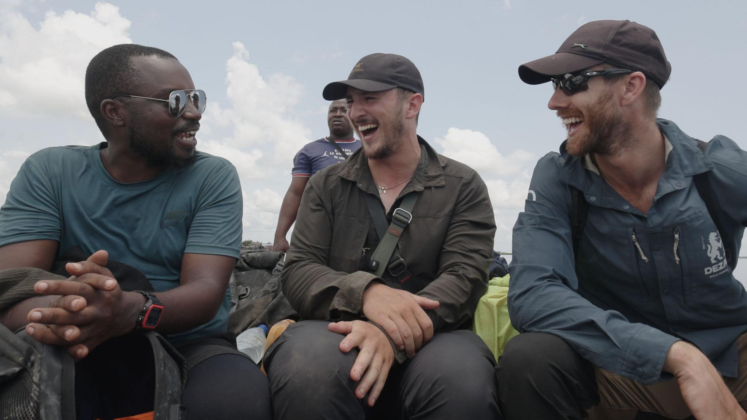 Obed, Will and Ash laughing in a boat after completing their challenge.