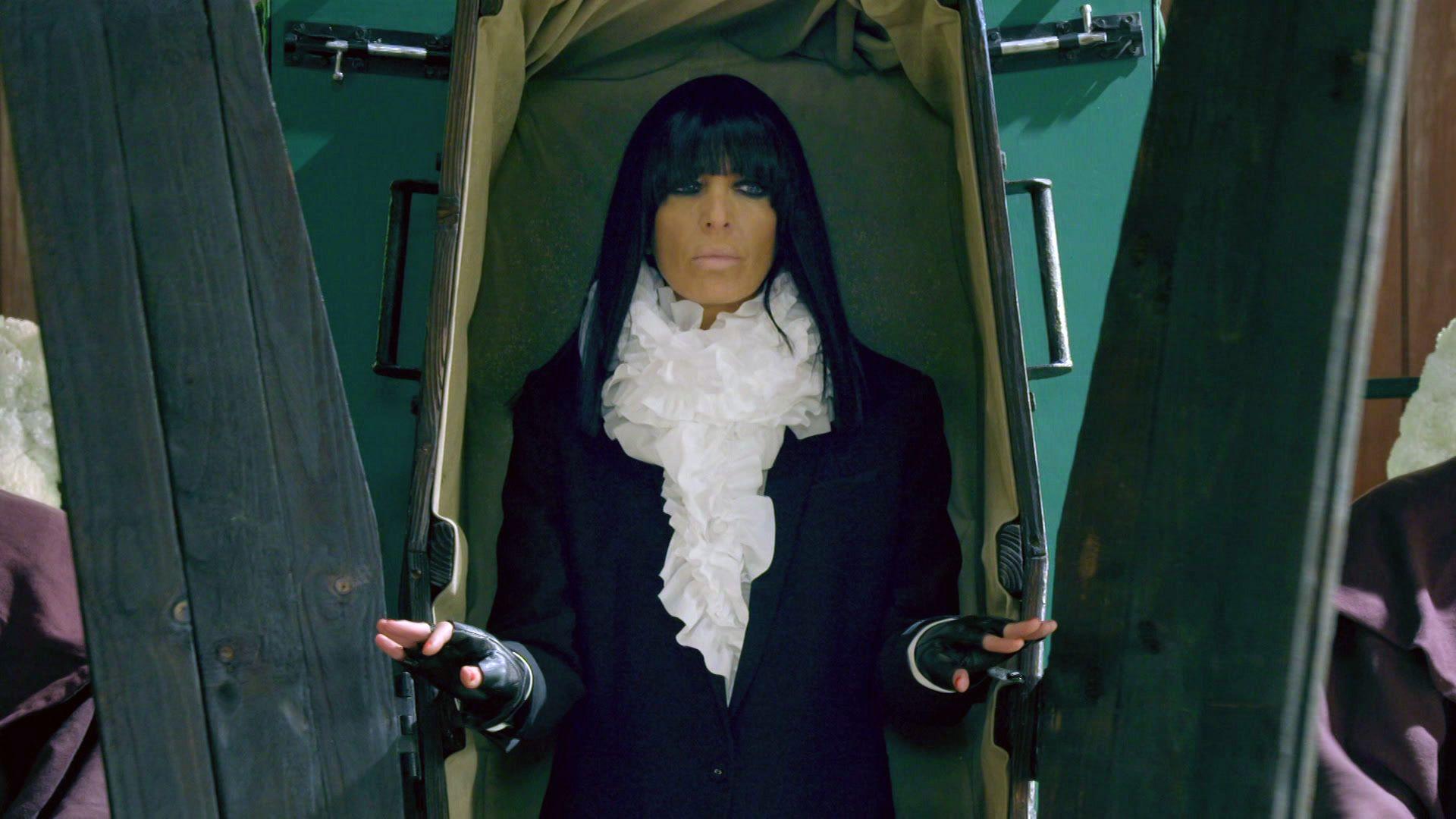 Claudia Winkleman emerging from a coffin