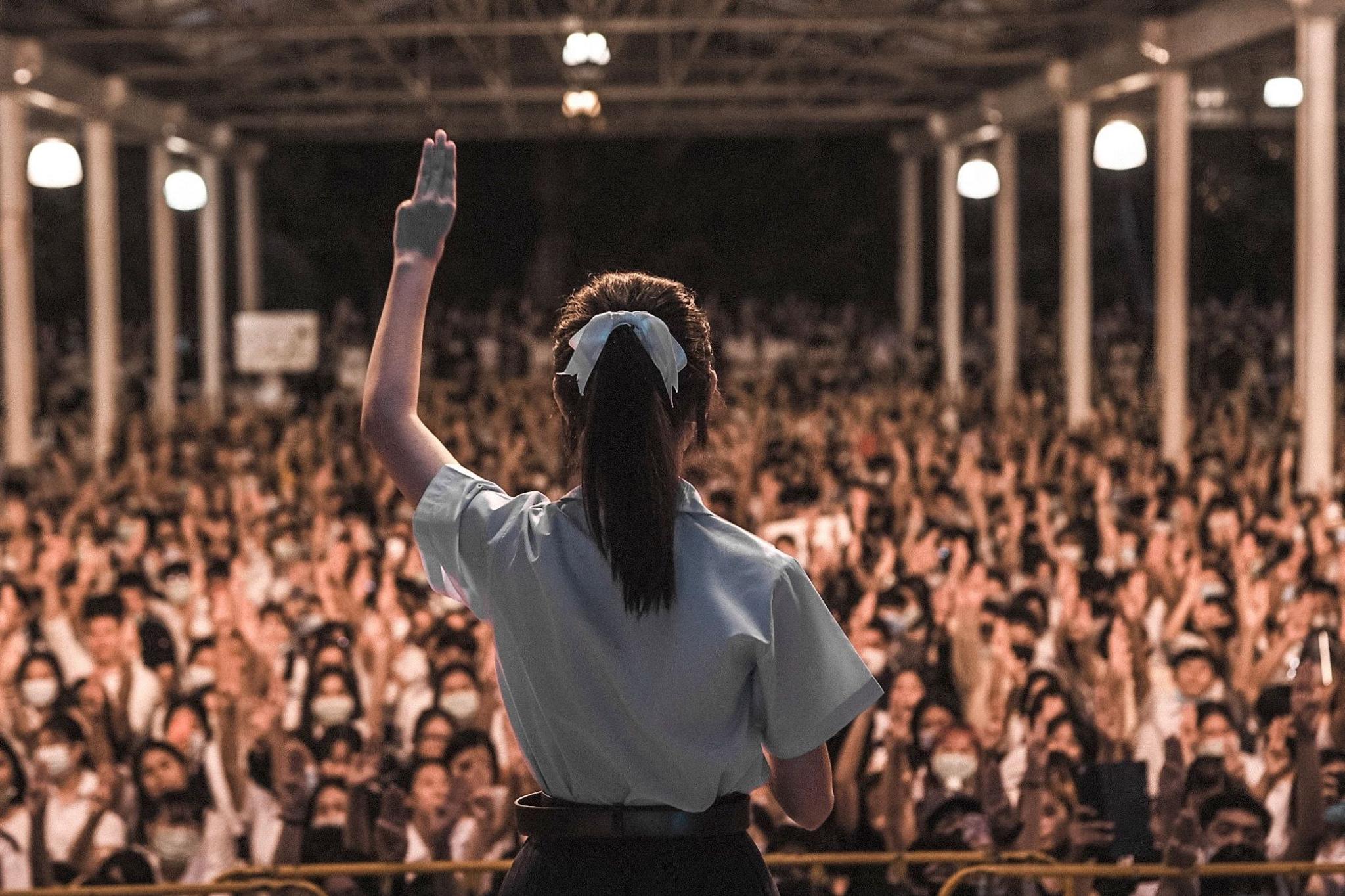 Supitcha Melinn Chailom doing the three-finger salute in August 2020 in front of a crowd of protesters