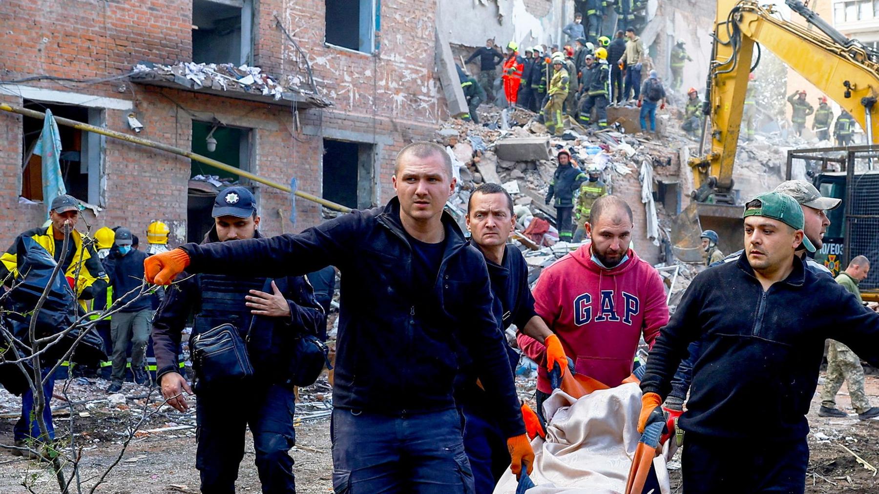 People carry a casualty, as emergency services work to rescue residents from under the debris at the site of an apartment building which was hit by a Russian missile strike in the town of Pryluky, amid Russia’s attack on Ukraine, in the Chernihiv region, Ukraine, October 7, 2026. REUTERS/Valentyn Ogirenko      TPX IMAGES OF THE DAY