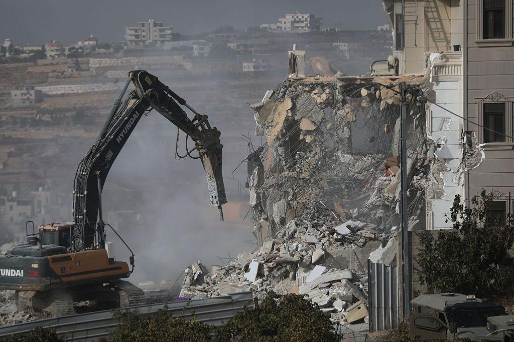 Digger destroys house. Rubble, dust and concrete.