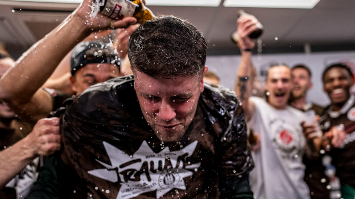 Fabian Hurzeler is covered in beer by his players after guiding St Pauli to promotion to the Bundesliga in 2024