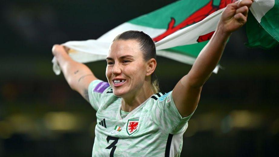 Gemma Evans in green top with a Wales flag after victory over Republic of Ireland in 2024