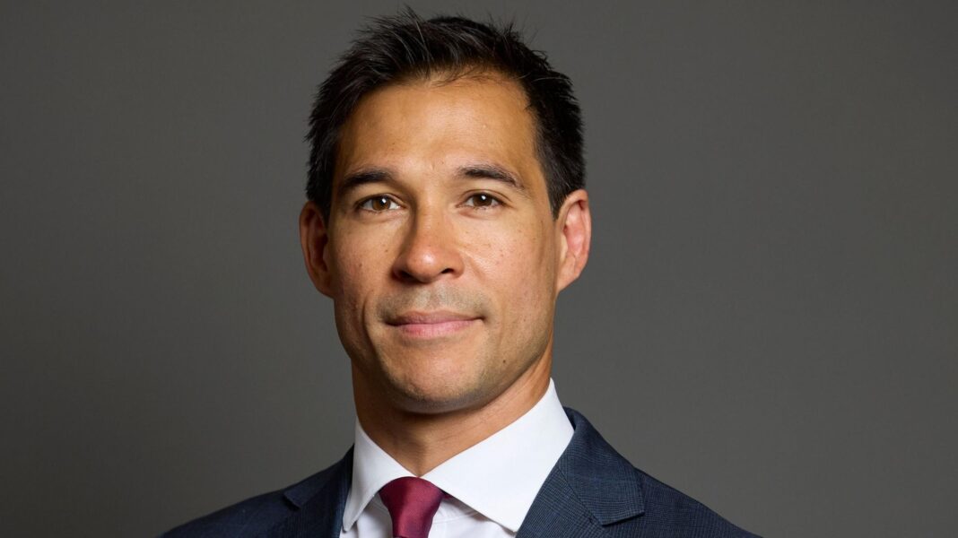 MP apologises over bullying and harassment A politician. He is wearing a dark blue suit and has a red tie.