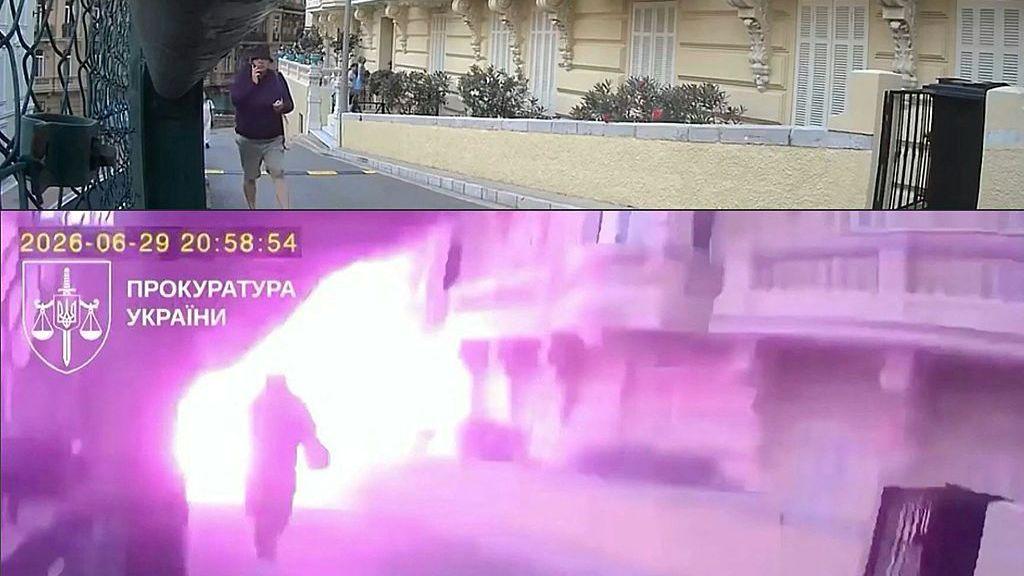 A still from a video shows a figure walking from a building on a phone and carrying a bag