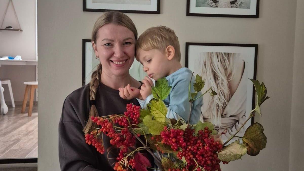 A blond woman holding a child in her arms