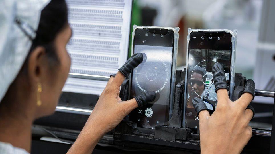 An employee tests the camera quality of mobile phones at a unit of Foxconn Technology Co in Andhra Pradesh state in southern India.