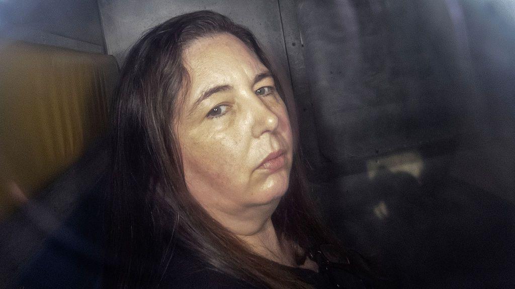 A woman with long brown hair looking at camera