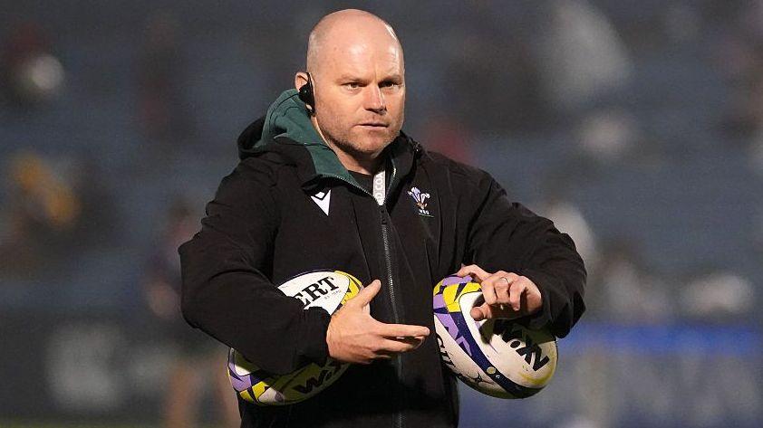 Sean Lynn holding two WXV rugby balls
