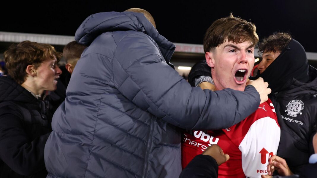 Conor Haughey celebrates with Fleetwood's fans who swarmed the pitch after their EFL Cup win against Arsenal