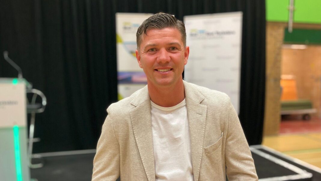 Reform UK mayor investigated over naked photo claims Luke Campbell standing by a stage on election night. He has short dark hair and is wearing a cream jacket and white T-shirt