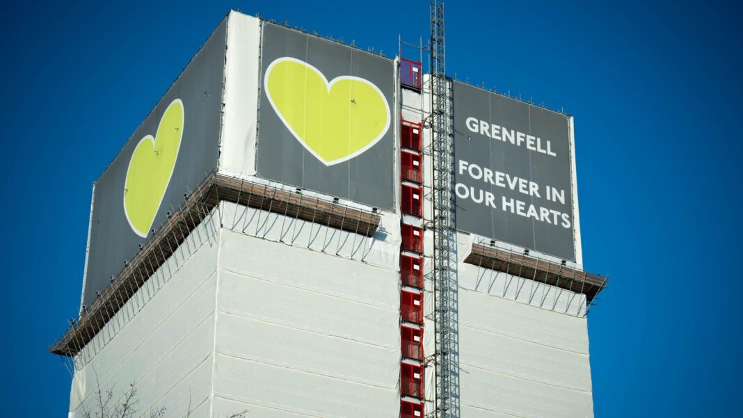 London Fire Brigade named in Met’s evidence file on Grenfell fire A tower block covered in white wrapping. There is a sign on top saying 'Grenfell - forever in our hearts'